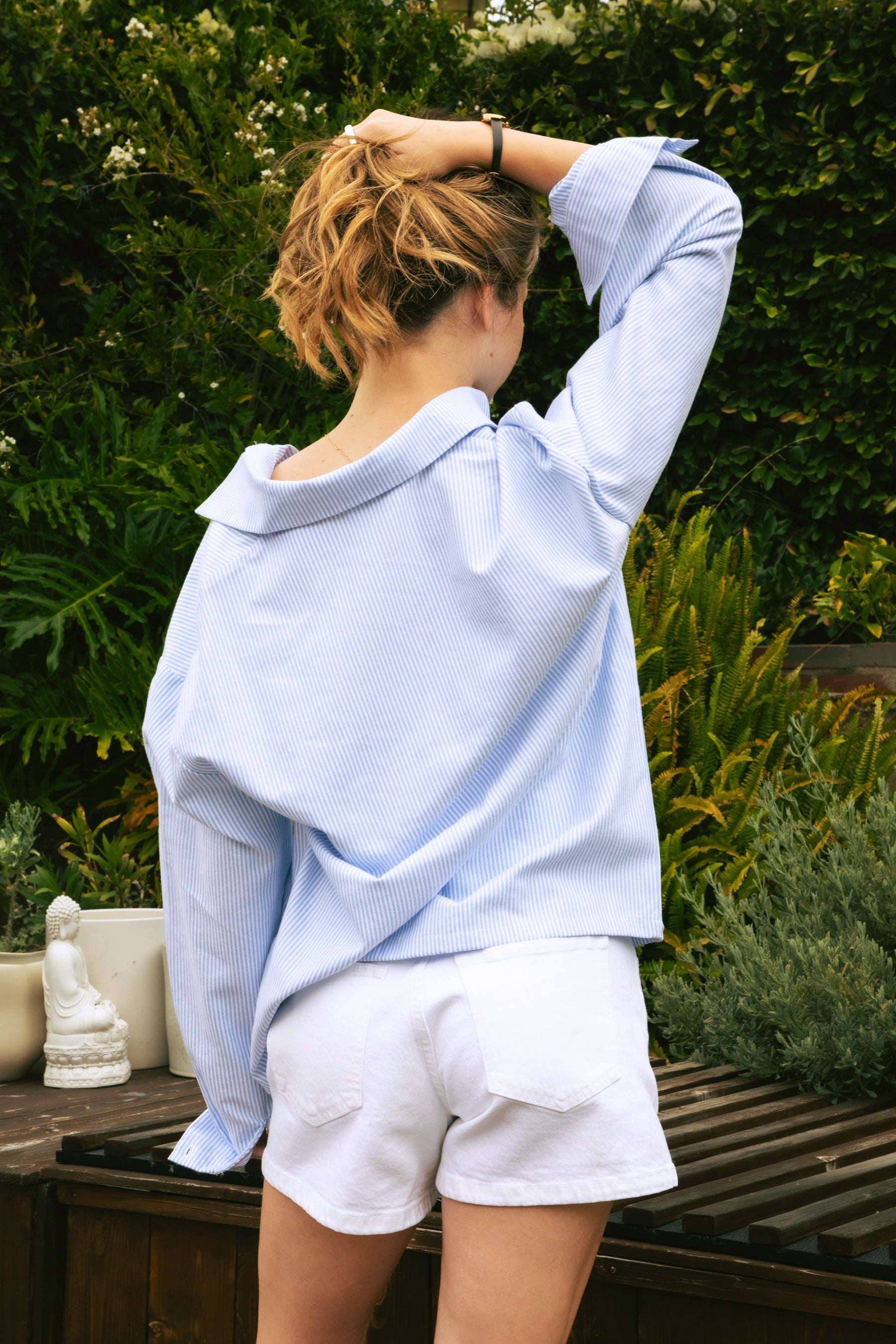 Woman wearing BLAIRE stripe oversized button down shirt featuring classic stripe oxford fabric, relaxed oversized silhouette, collared neckline, full front button closure, dropped shoulders, long sleeves with button cuffs, and functional chest pocket for effortless layering.