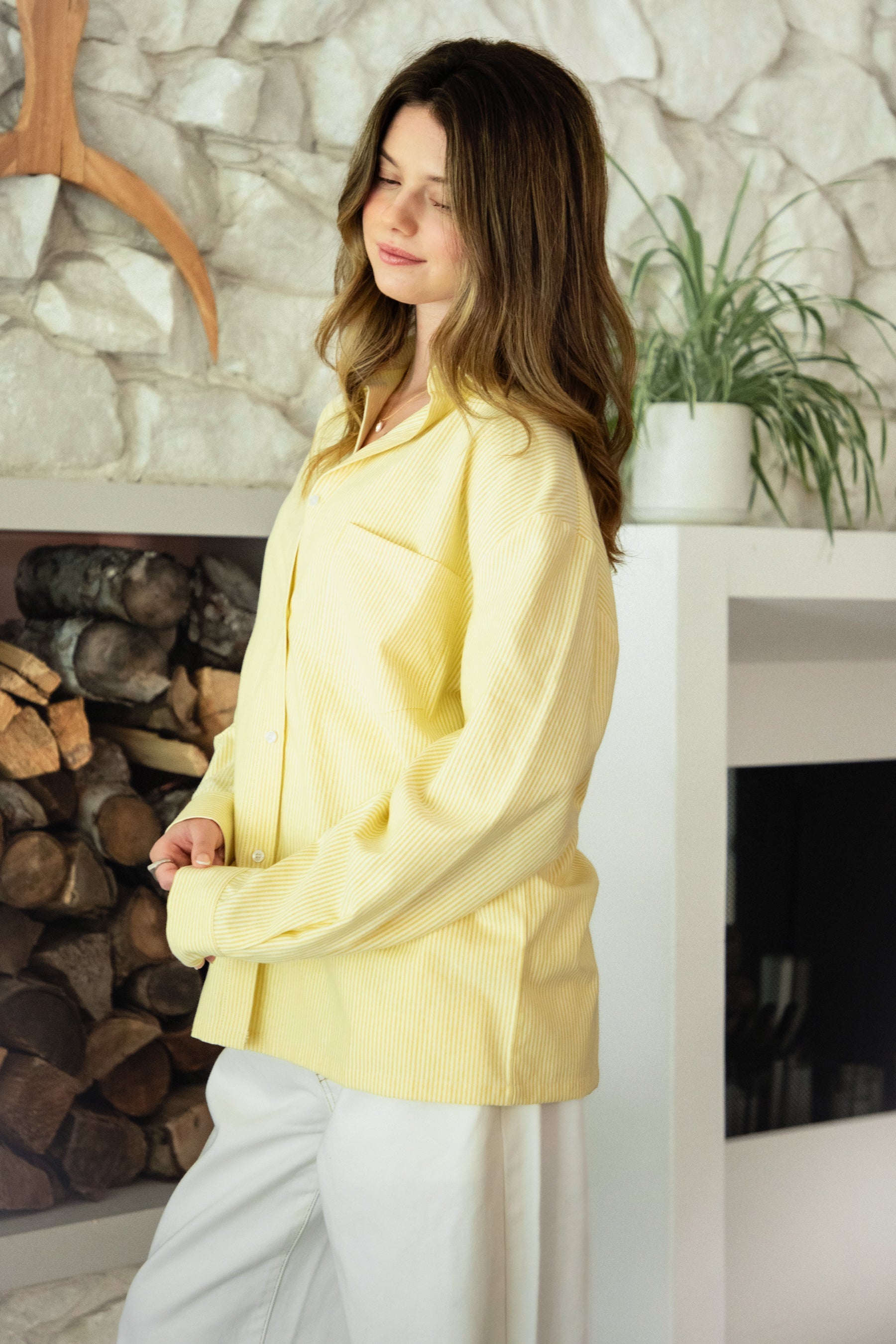 Woman wearing BLAIRE stripe oversized button down shirt featuring classic stripe oxford fabric, relaxed oversized silhouette, collared neckline, full front button closure, dropped shoulders, long sleeves with button cuffs, and functional chest pocket for effortless layering.