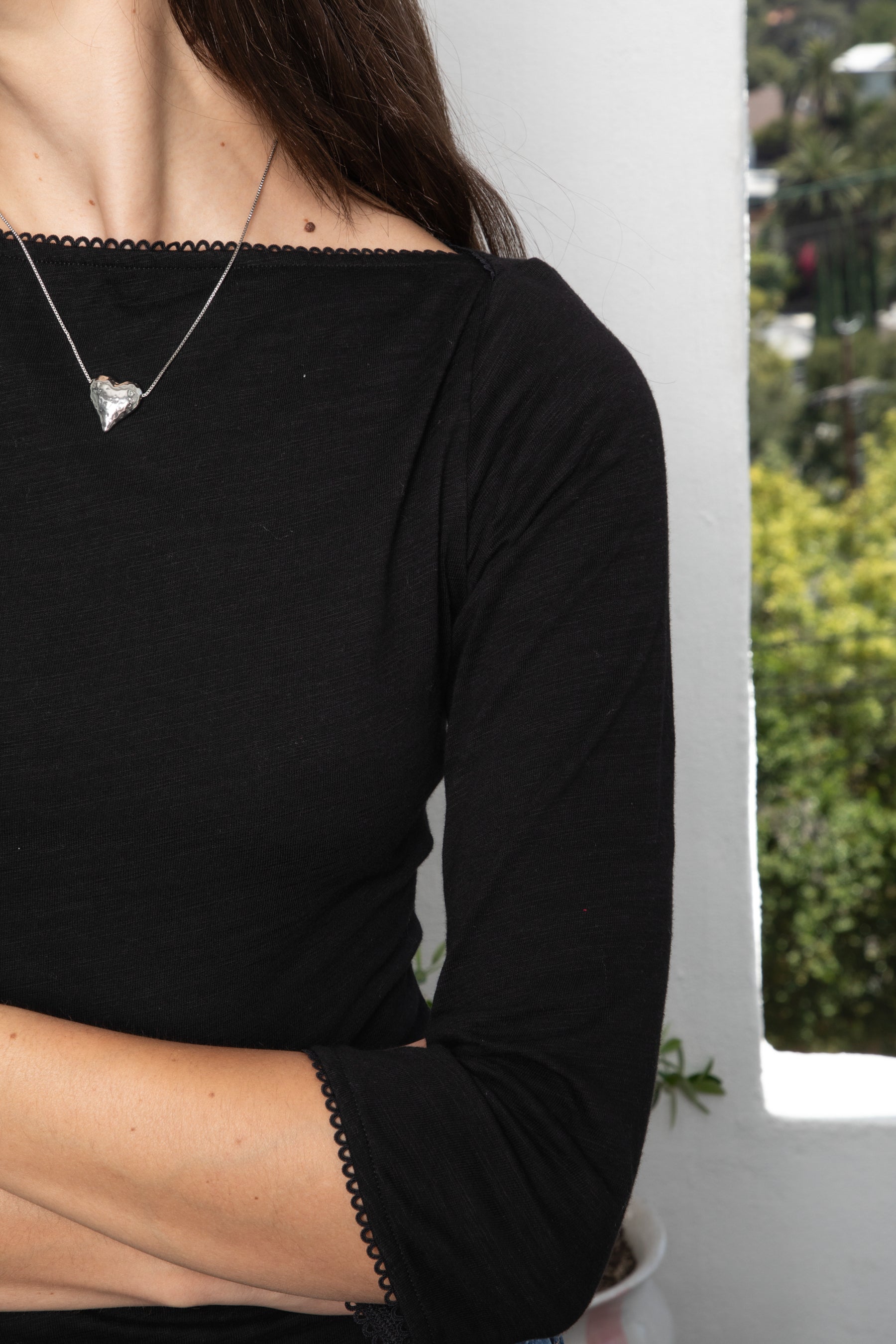 Woman wearing LUMA cotton rib three quarter sleeve boat neck top featuring soft cotton slub jersey, lightweight breathable feel, classic boat neckline, delicate picot trim, three quarter sleeves with matching cuff trim, picot trim hem, relaxed slim fit, and subtle curved hem.