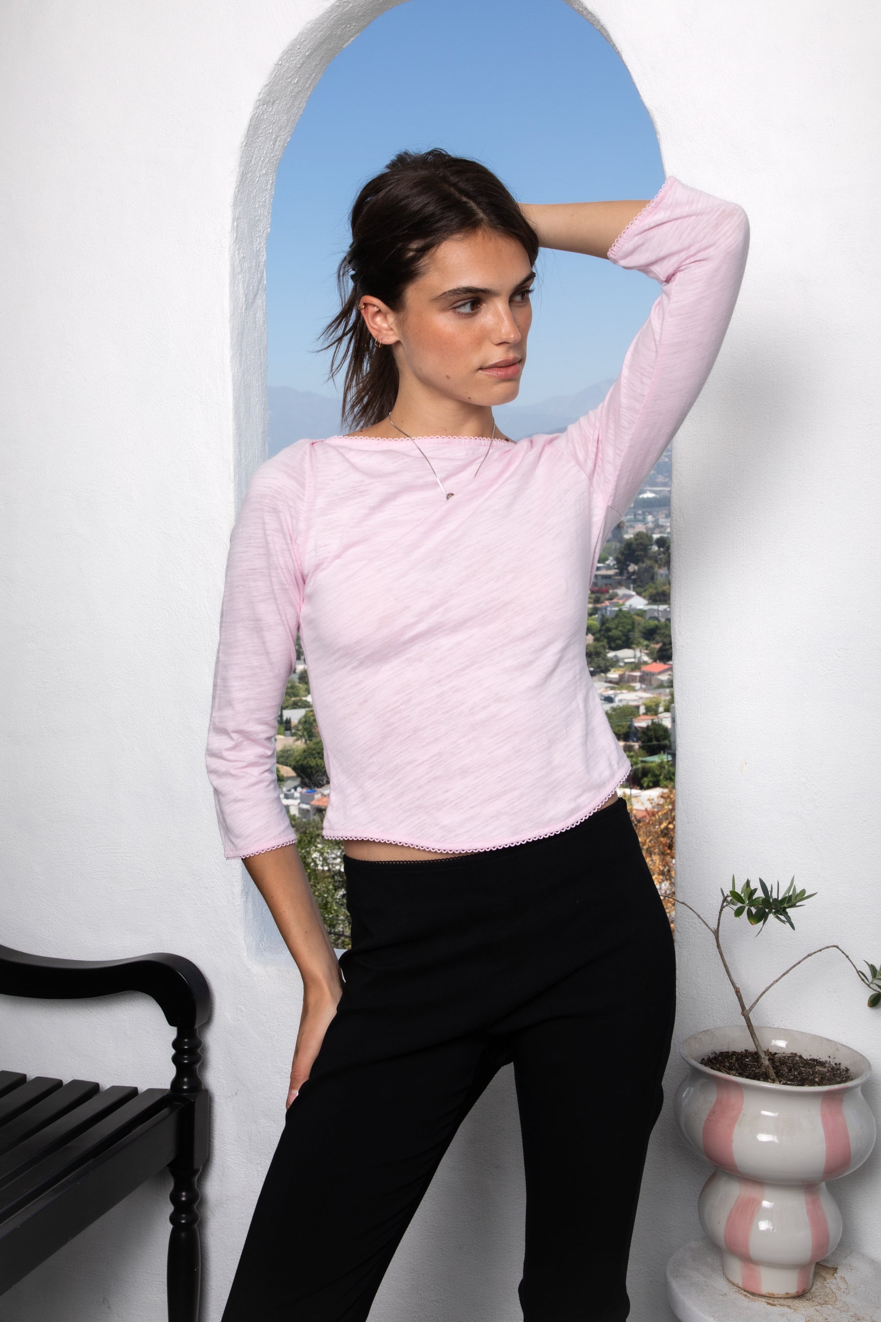 Woman wearing LUMA cotton rib three quarter sleeve boat neck top featuring soft cotton slub jersey, lightweight breathable feel, classic boat neckline, delicate picot trim, three quarter sleeves with matching cuff trim, picot trim hem, relaxed slim fit, and subtle curved hem.
