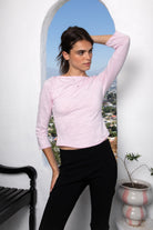 Woman wearing LUMA cotton rib three quarter sleeve boat neck top featuring soft cotton slub jersey, lightweight breathable feel, classic boat neckline, delicate picot trim, three quarter sleeves with matching cuff trim, picot trim hem, relaxed slim fit, and subtle curved hem.