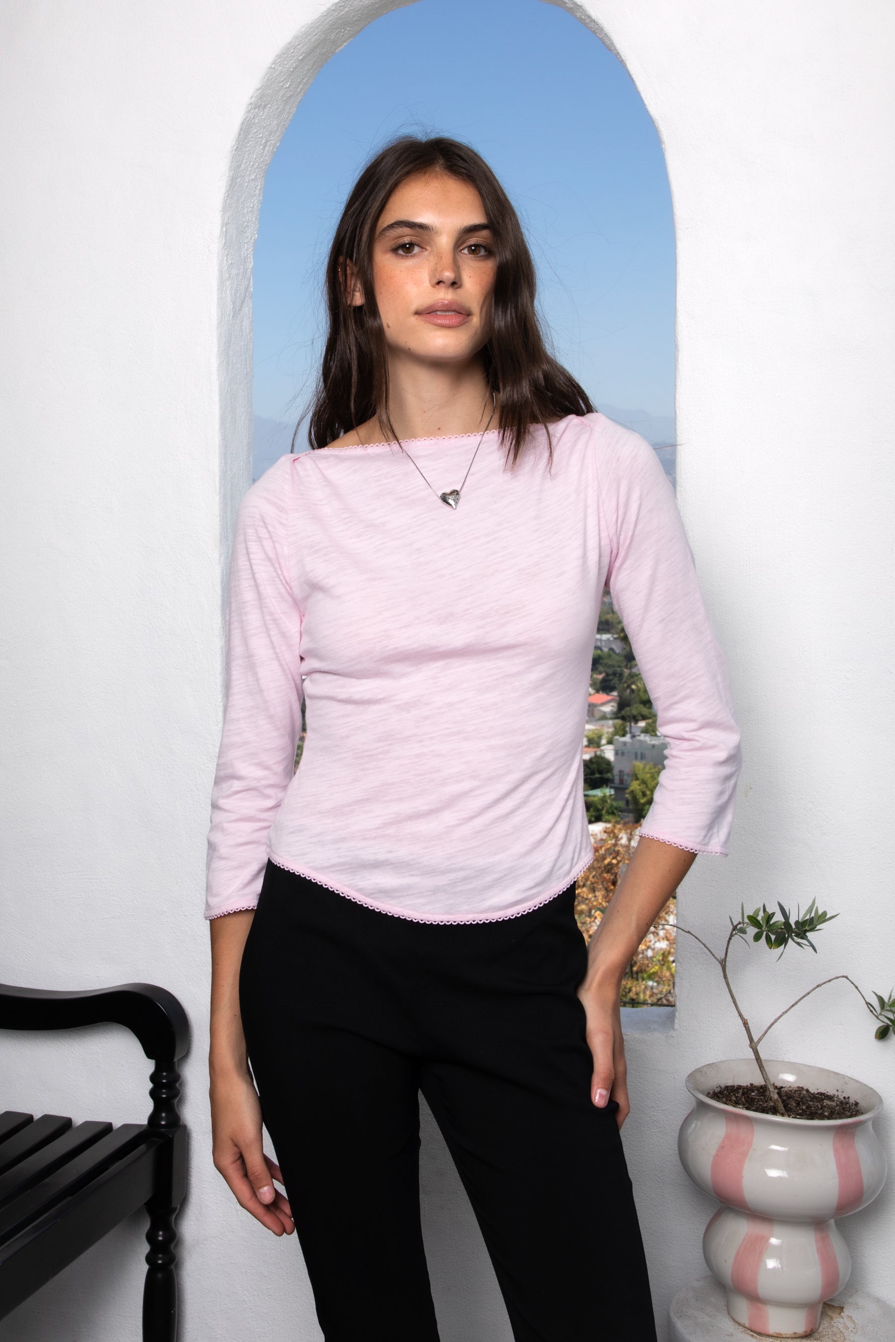 Woman wearing LUMA cotton rib three quarter sleeve boat neck top featuring soft cotton slub jersey, lightweight breathable feel, classic boat neckline, delicate picot trim, three quarter sleeves with matching cuff trim, picot trim hem, relaxed slim fit, and subtle curved hem.