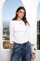 Woman wearing LUMA cotton rib three quarter sleeve boat neck top featuring soft cotton slub jersey, lightweight breathable feel, classic boat neckline, delicate picot trim, three quarter sleeves with matching cuff trim, picot trim hem, relaxed slim fit, and subtle curved hem.