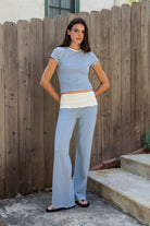 Woman wearing BRISA French terry stripe crewneck short sleeve top featuring soft stretch French terry fabric, classic crewneck design, contrast neckband detail, slim fitted short sleeves, timeless yarn dye stripe pattern, and semi cropped length for easy everyday styling.
