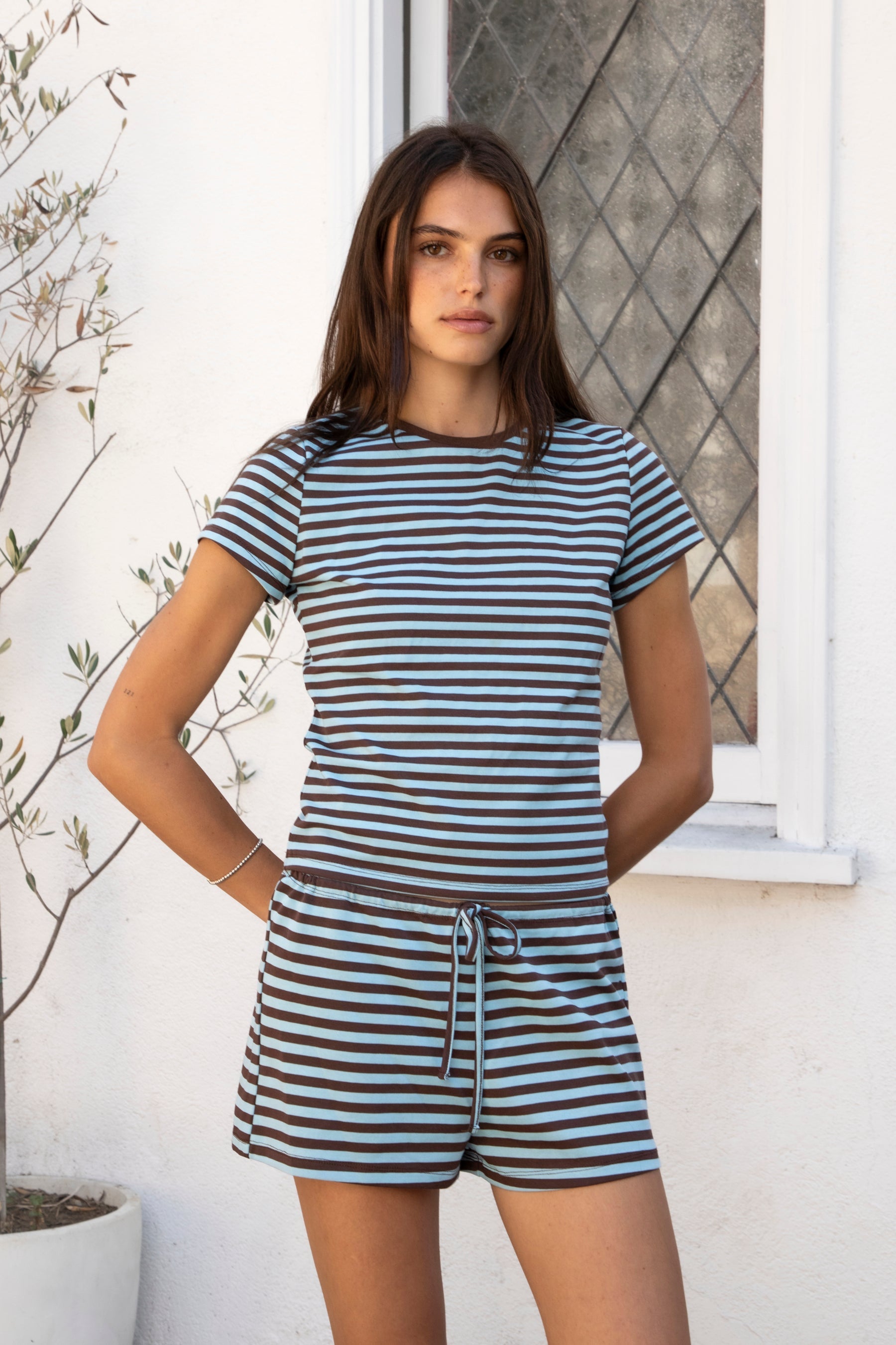 Woman wearing MARLOWE classic crewneck stripe short sleeve t-shirt featuring soft cotton blend fabric, lightweight comfortable feel, timeless striped pattern, classic crew neckline, short sleeves, relaxed slim fit, and effortless essential design for layering or everyday styling.