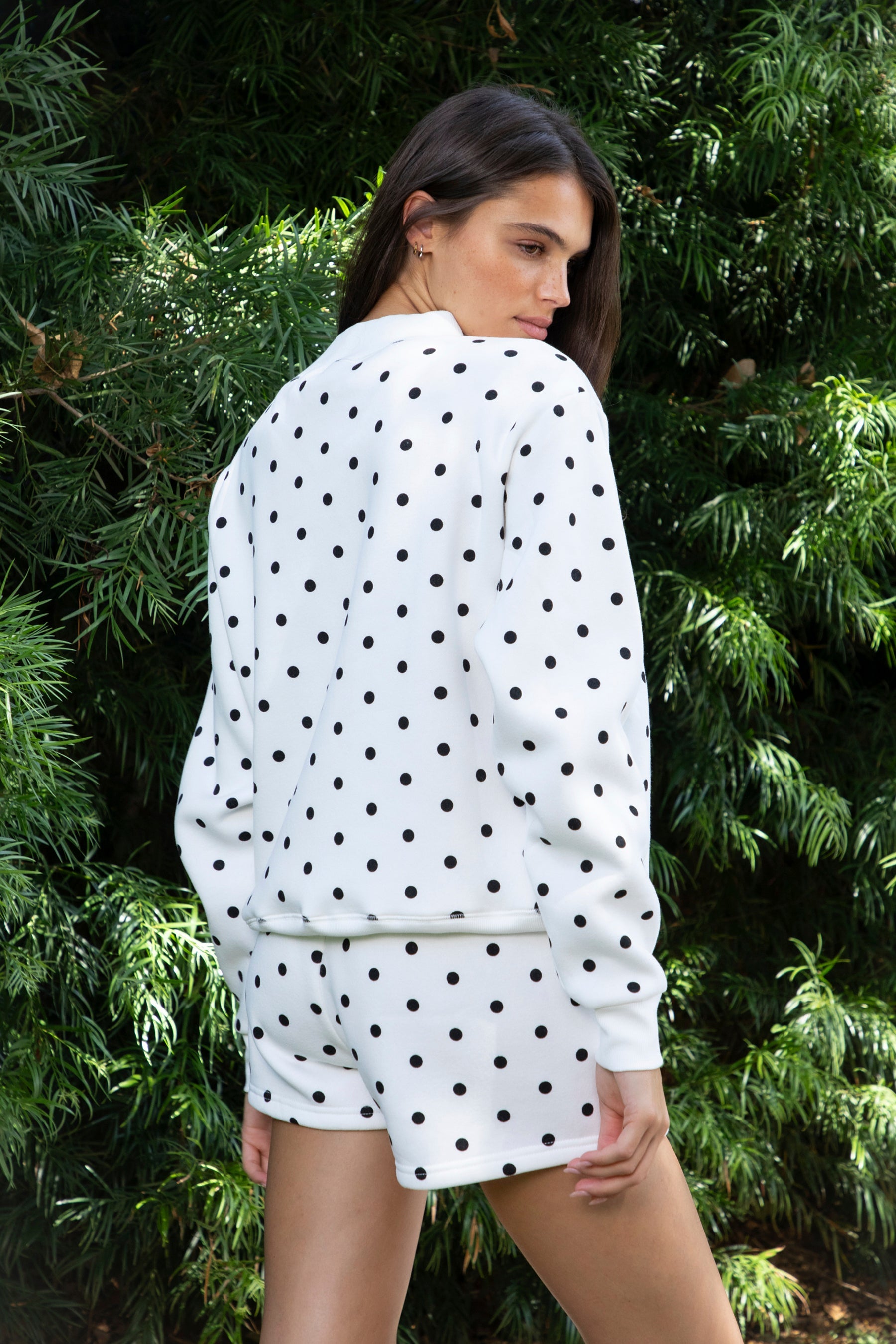 Woman wearing PIPPA polka dot plush fleece mock neck sweatshirt featuring soft cotton blend fleece fabric, allover polka dot print, classic crew neckline with ribbed trim, relaxed silhouette, long sleeves with dropped shoulders, ribbed cuffs and hem, and cozy construction designed to pair with the matching PIPPA shorts.
