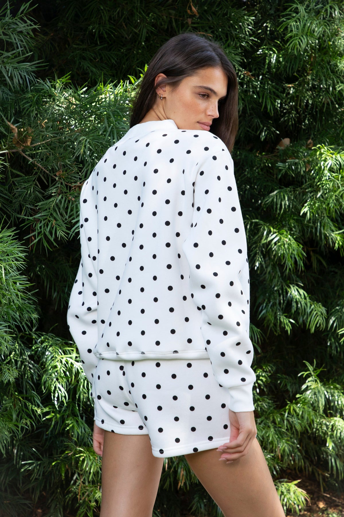 Woman wearing PIPPA polka dot plush fleece mock neck sweatshirt featuring soft cotton blend fleece fabric, allover polka dot print, classic crew neckline with ribbed trim, relaxed silhouette, long sleeves with dropped shoulders, ribbed cuffs and hem, and cozy construction designed to pair with the matching PIPPA shorts.