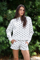 Woman wearing PIPPA polka dot plush fleece mock neck sweatshirt featuring soft cotton blend fleece fabric, allover polka dot print, classic crew neckline with ribbed trim, relaxed silhouette, long sleeves with dropped shoulders, ribbed cuffs and hem, and cozy construction designed to pair with the matching PIPPA shorts.