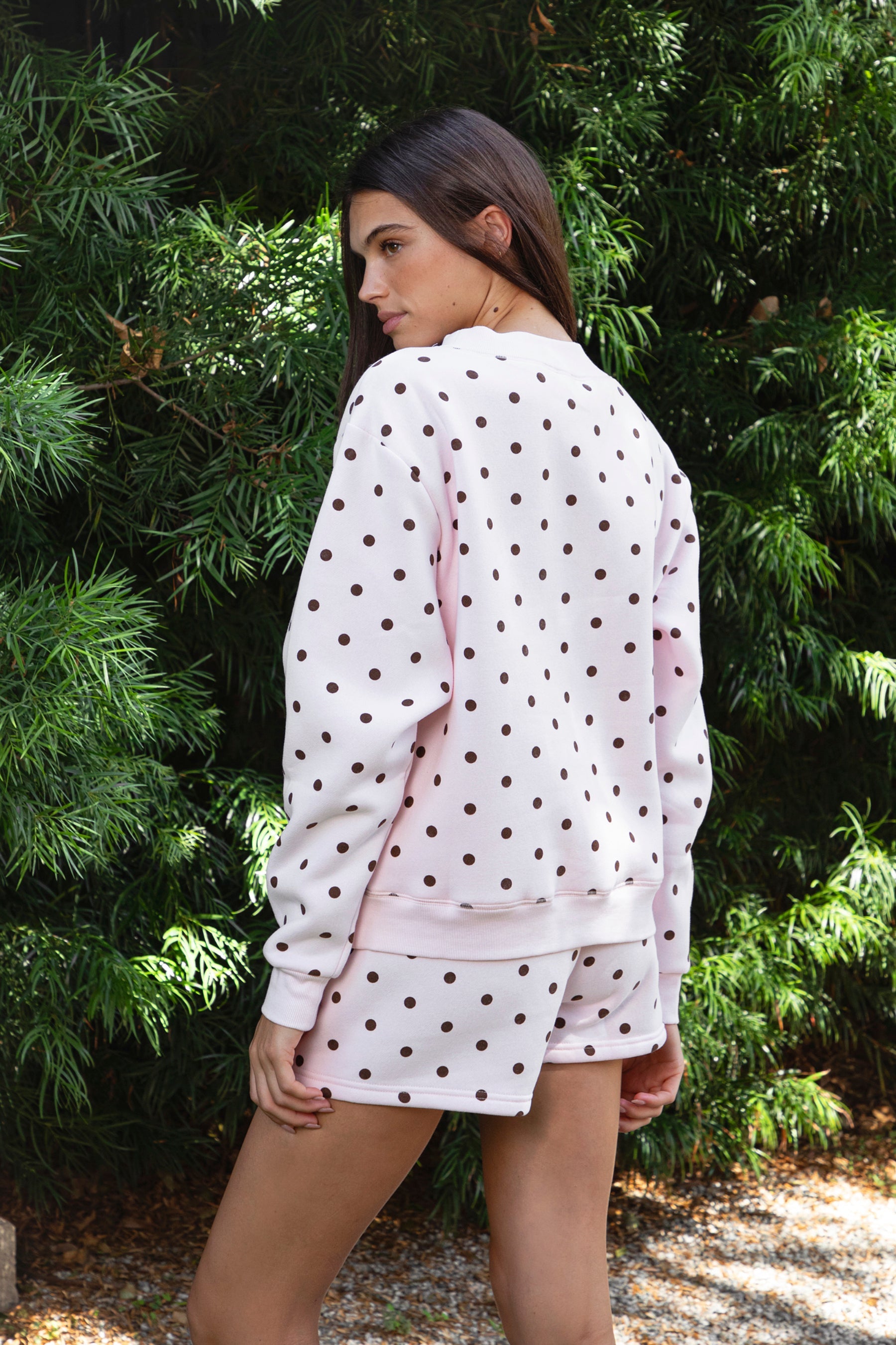 Woman wearing PIPPA polka dot plush fleece mock neck sweatshirt featuring soft cotton blend fleece fabric, allover polka dot print, classic crew neckline with ribbed trim, relaxed silhouette, long sleeves with dropped shoulders, ribbed cuffs and hem, and cozy construction designed to pair with the matching PIPPA shorts.