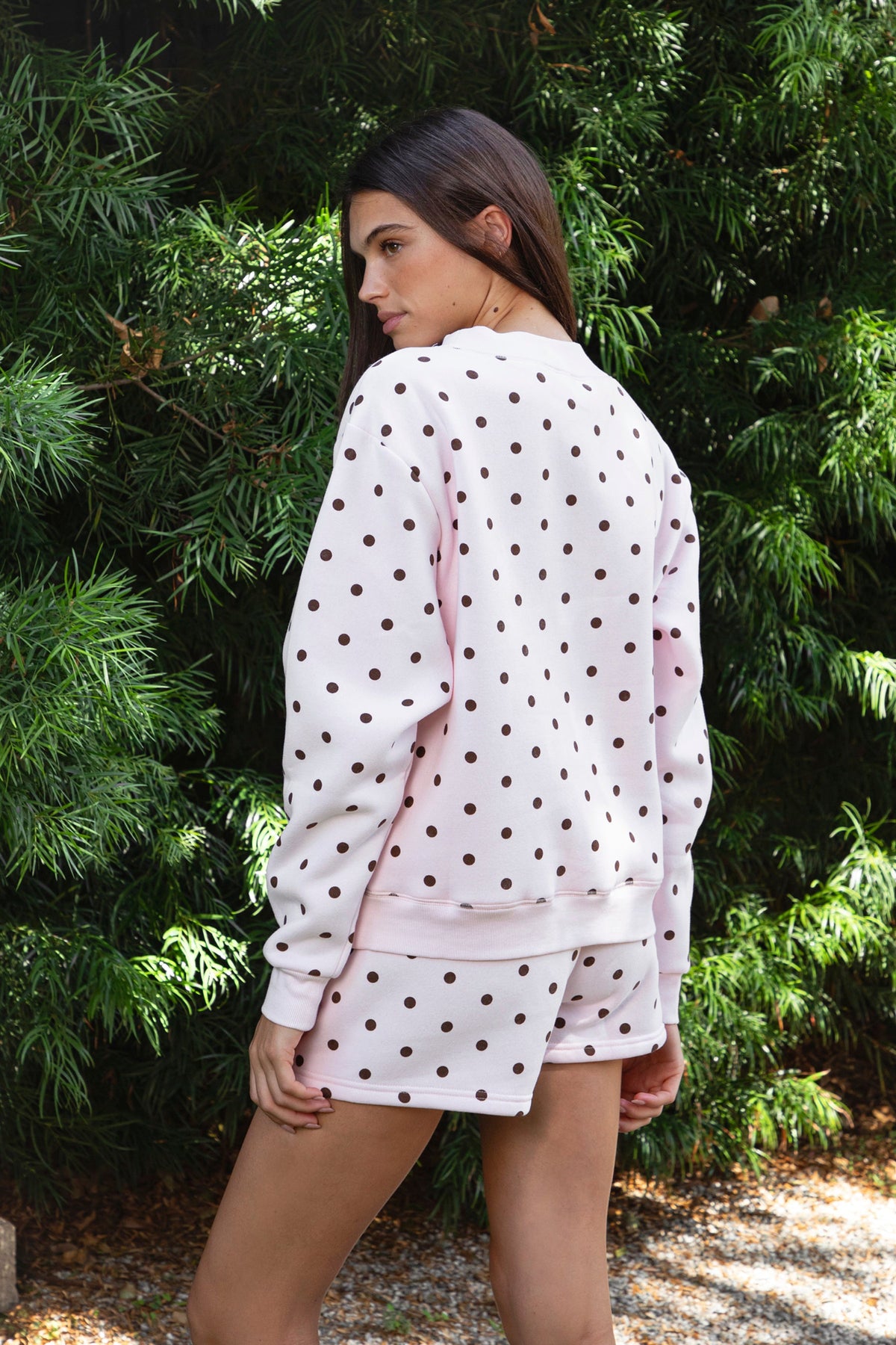 Woman wearing PIPPA polka dot plush fleece mock neck sweatshirt featuring soft cotton blend fleece fabric, allover polka dot print, classic crew neckline with ribbed trim, relaxed silhouette, long sleeves with dropped shoulders, ribbed cuffs and hem, and cozy construction designed to pair with the matching PIPPA shorts.