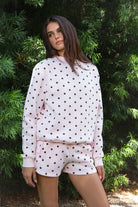 Woman wearing PIPPA polka dot plush fleece mock neck sweatshirt featuring soft cotton blend fleece fabric, allover polka dot print, classic crew neckline with ribbed trim, relaxed silhouette, long sleeves with dropped shoulders, ribbed cuffs and hem, and cozy construction designed to pair with the matching PIPPA shorts.