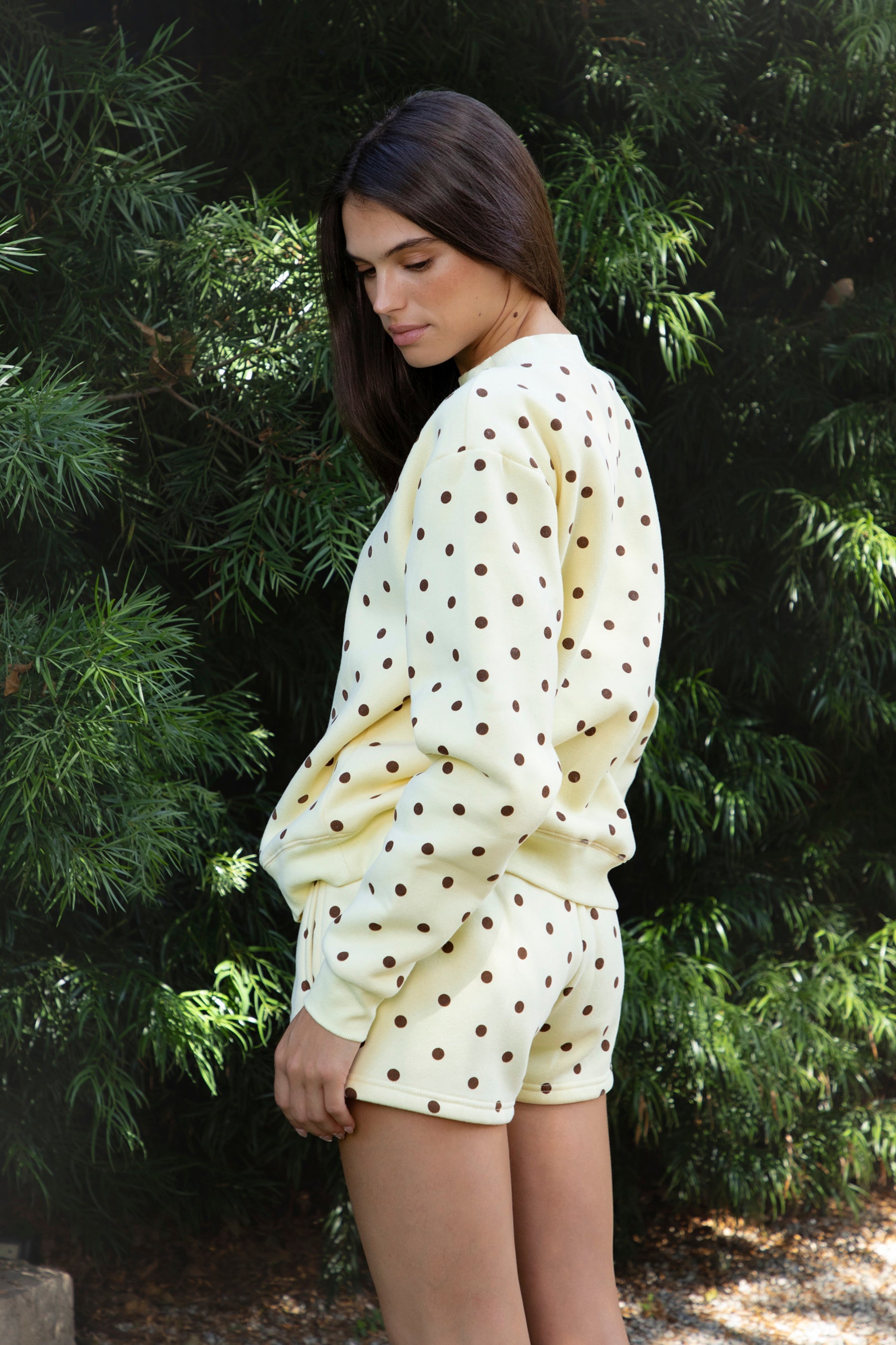 Woman wearing PIPPA polka dot plush fleece mock neck sweatshirt featuring soft cotton blend fleece fabric, allover polka dot print, classic crew neckline with ribbed trim, relaxed silhouette, long sleeves with dropped shoulders, ribbed cuffs and hem, and cozy construction designed to pair with the matching PIPPA shorts.