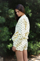 Woman wearing PIPPA polka dot plush fleece mock neck sweatshirt featuring soft cotton blend fleece fabric, allover polka dot print, classic crew neckline with ribbed trim, relaxed silhouette, long sleeves with dropped shoulders, ribbed cuffs and hem, and cozy construction designed to pair with the matching PIPPA shorts.