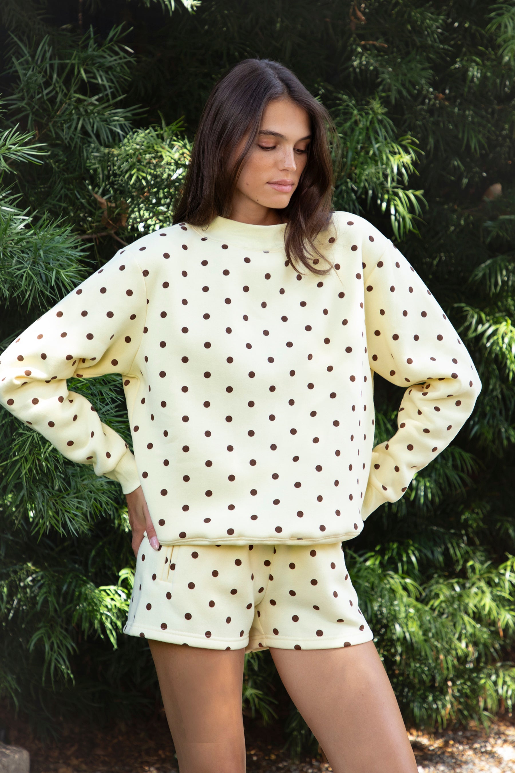 Woman wearing PIPPA polka dot plush fleece mock neck sweatshirt featuring soft cotton blend fleece fabric, allover polka dot print, classic crew neckline with ribbed trim, relaxed silhouette, long sleeves with dropped shoulders, ribbed cuffs and hem, and cozy construction designed to pair with the matching PIPPA shorts.