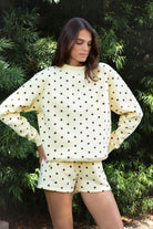 Woman wearing PIPPA polka dot plush fleece mock neck sweatshirt featuring soft cotton blend fleece fabric, allover polka dot print, classic crew neckline with ribbed trim, relaxed silhouette, long sleeves with dropped shoulders, ribbed cuffs and hem, and cozy construction designed to pair with the matching PIPPA shorts.