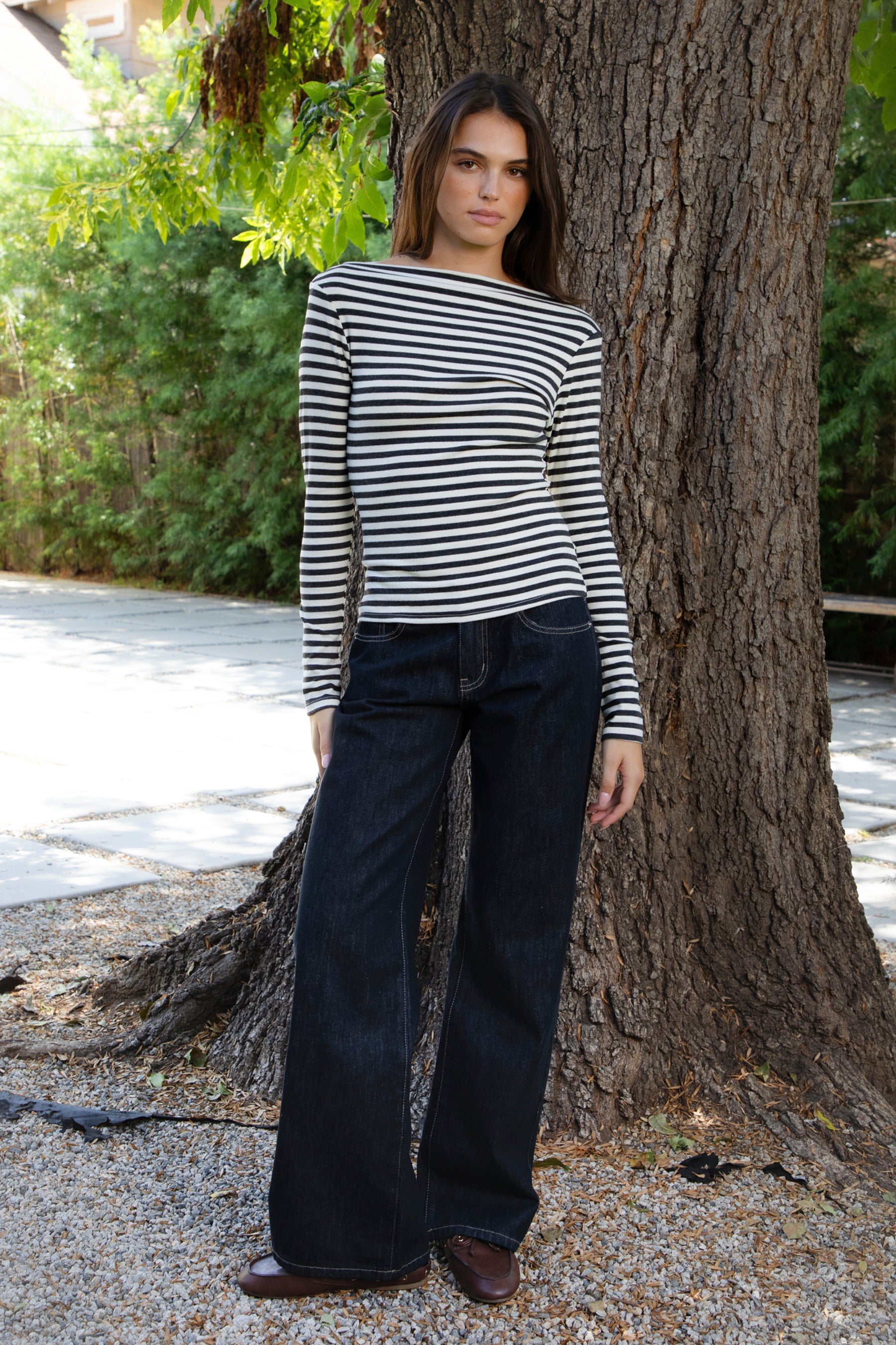 Woman wearing ROSLYN striped boat neck long sleeve top featuring soft brushed cotton stretch jersey fabric, classic horizontal stripe pattern, wide boat neckline that can be styled on or slightly off the shoulder, fitted silhouette, slim full length sleeves, and hip length hem for easy everyday styling.