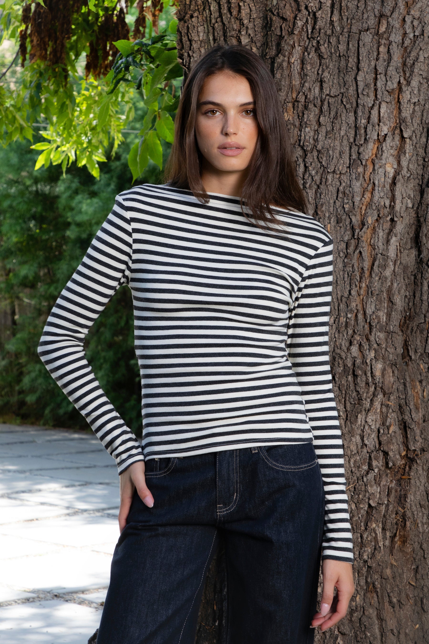 Woman wearing ROSLYN striped boat neck long sleeve top featuring soft brushed cotton stretch jersey fabric, classic horizontal stripe pattern, wide boat neckline that can be styled on or slightly off the shoulder, fitted silhouette, slim full length sleeves, and hip length hem for easy everyday styling.