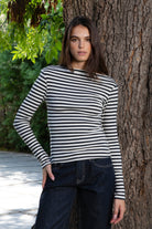 Woman wearing ROSLYN striped boat neck long sleeve top featuring soft brushed cotton stretch jersey fabric, classic horizontal stripe pattern, wide boat neckline that can be styled on or slightly off the shoulder, fitted silhouette, slim full length sleeves, and hip length hem for easy everyday styling.
