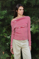 Woman wearing ROSLYN striped boat neck long sleeve top featuring soft brushed cotton stretch jersey fabric, classic horizontal stripe pattern, wide boat neckline that can be styled on or slightly off the shoulder, fitted silhouette, slim full length sleeves, and hip length hem for easy everyday styling.