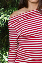 Woman wearing ROSLYN striped boat neck long sleeve top featuring soft brushed cotton stretch jersey fabric, classic horizontal stripe pattern, wide boat neckline that can be styled on or slightly off the shoulder, fitted silhouette, slim full length sleeves, and hip length hem for easy everyday styling.