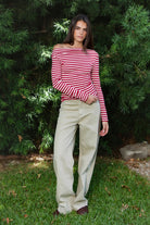 Woman wearing ROSLYN striped boat neck long sleeve top featuring soft brushed cotton stretch jersey fabric, classic horizontal stripe pattern, wide boat neckline that can be styled on or slightly off the shoulder, fitted silhouette, slim full length sleeves, and hip length hem for easy everyday styling.
