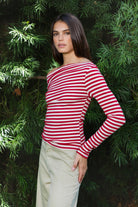 Woman wearing ROSLYN striped boat neck long sleeve top featuring soft brushed cotton stretch jersey fabric, classic horizontal stripe pattern, wide boat neckline that can be styled on or slightly off the shoulder, fitted silhouette, slim full length sleeves, and hip length hem for easy everyday styling.