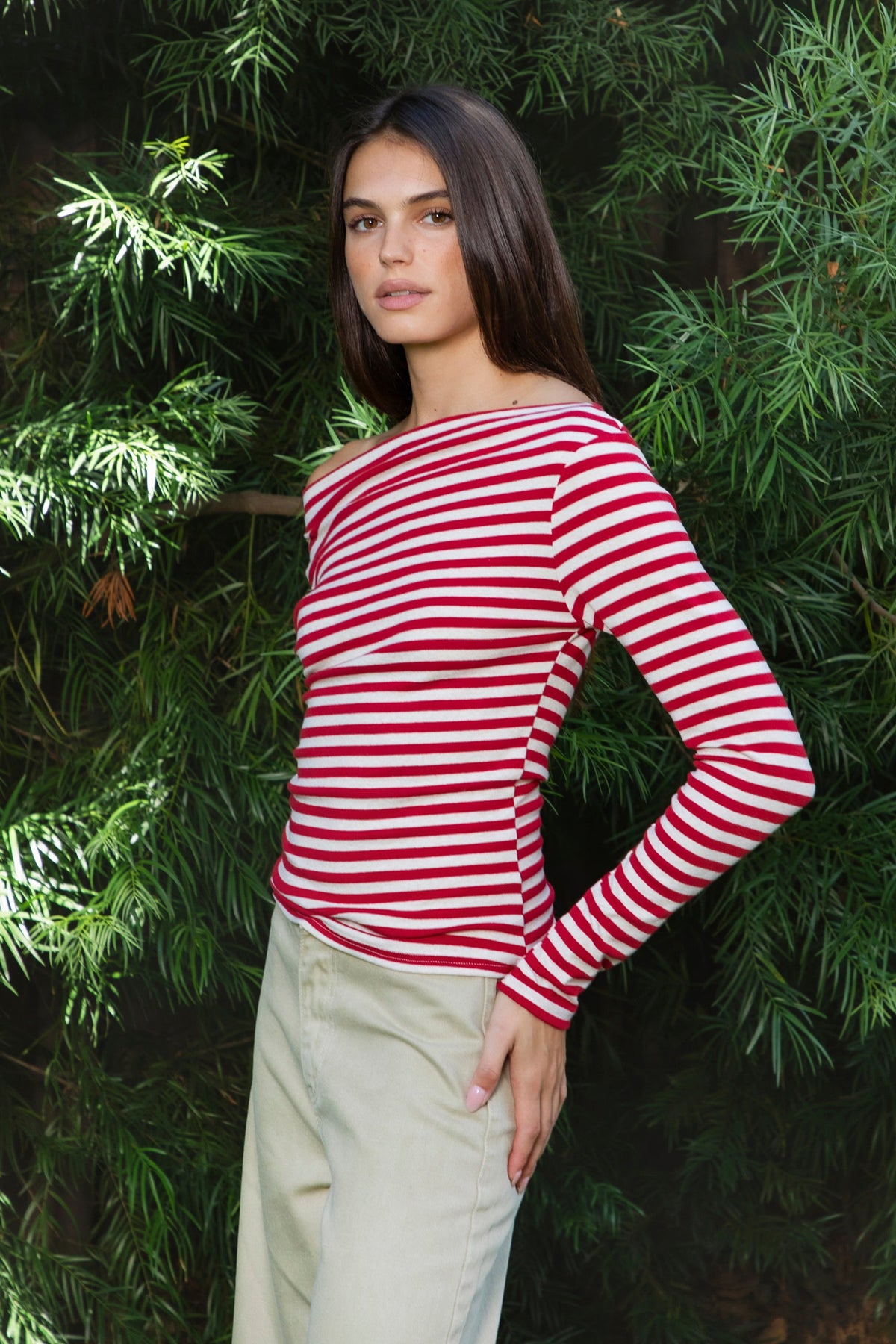 Woman wearing ROSLYN striped boat neck long sleeve top featuring soft brushed cotton stretch jersey fabric, classic horizontal stripe pattern, wide boat neckline that can be styled on or slightly off the shoulder, fitted silhouette, slim full length sleeves, and hip length hem for easy everyday styling.