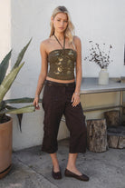 Woman wearing TIC TOC TC31322 KEZIA CREAM Mesh Sequin Embroidered Top with a brown capri pants 