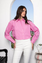 Woman wearing HAMPTON classic stripe collared cropped poplin shirt featuring classic stripe cotton fabric, crisp point collar, button front closure, ultra cropped relaxed silhouette, dropped shoulders, long sleeves with button cuffs, and clean back yoke detail for a polished modern tailored look.