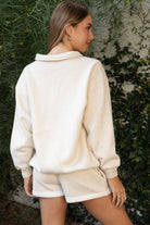 Woman wearing TIC TOC TJ31645-ARDYN ARDYN classic polo collar long sleeve top featuring a two-button front placket, drop shoulder relaxed sleeves, easy loose fit, and ribbed cuffs and hem, styled with simple bottoms for a cozy off-duty everyday look.