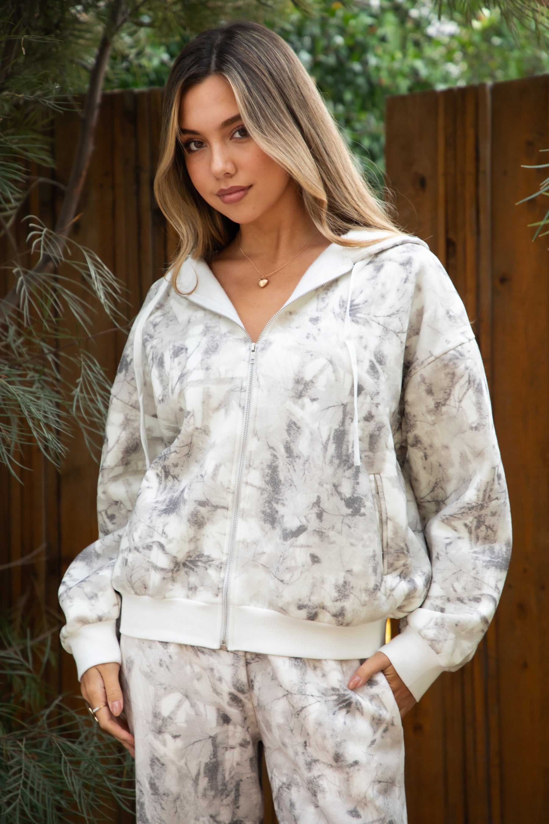 Woman wearing TIC TOC TJ31822-AVERY-JK AVERY light camo wood fleece classic oversized hoodie featuring a relaxed zip-up front, attached hood with adjustable drawstrings, front kangaroo pocket, and ribbed cuffs and hem, styled with casual bottoms for a cozy off-duty lounge and streetwear look.