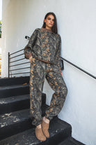 Woman wearing BAYOU dark woodland camo mock neck sweatshirt featuring soft cloud fleece fabric, allover woodland camo print, wide mock neckline with contrast ribbed trim, dropped shoulder relaxed silhouette, oversized fit, long sleeves, and contrast ribbed cuffs and hem.