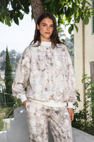 Woman wearing AVERY light woodland camo mock neck sweatshirt featuring soft cloud fleece construction, allover light woodland camo print, mock neckline with contrast ribbed trim, dropped shoulders, relaxed long sleeves, contrast ribbed cuffs and hem, and easy oversized fit for cozy everyday styling