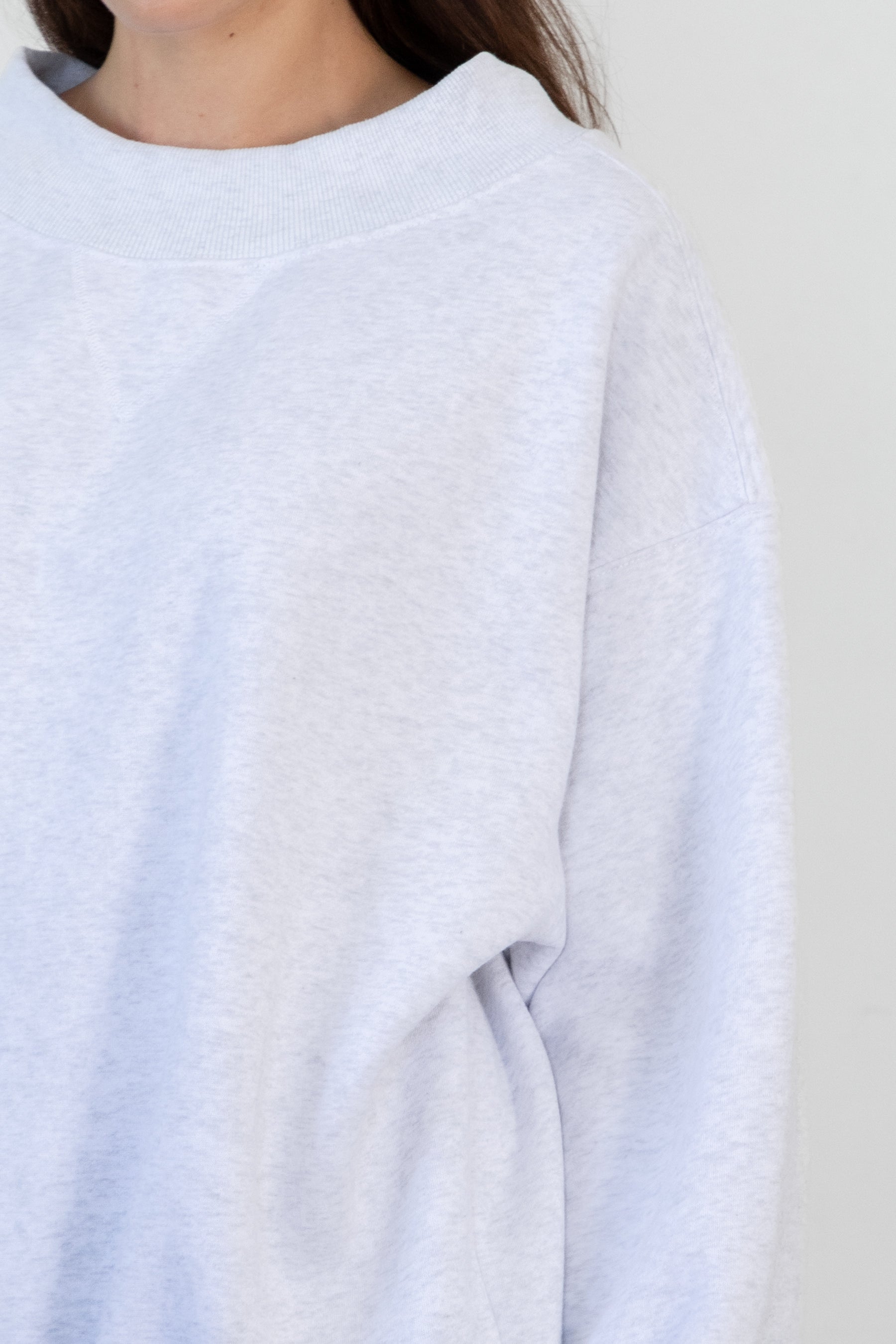 Woman wearing LANI mock neck cloud fleece sweatshirt featuring soft cotton blend cloud fleece fabric, ribbed mock neckline, relaxed oversized fit, dropped shoulder design, long sleeves with ribbed cuffs, triangle stitch detail at center front, and ribbed hem for a cozy comfortable finish.