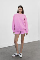 Woman wearing LANI mock neck cloud fleece sweatshirt featuring soft cotton blend cloud fleece fabric, ribbed mock neckline, relaxed oversized fit, dropped shoulder design, long sleeves with ribbed cuffs, triangle stitch detail at center front, and ribbed hem for a cozy comfortable finish.