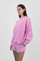 Woman wearing LANI mock neck cloud fleece sweatshirt featuring soft cotton blend cloud fleece fabric, ribbed mock neckline, relaxed oversized fit, dropped shoulder design, long sleeves with ribbed cuffs, triangle stitch detail at center front, and ribbed hem for a cozy comfortable finish.