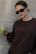 Woman wearing LANI mock neck cloud fleece sweatshirt featuring soft cotton blend cloud fleece fabric, ribbed mock neckline, relaxed oversized fit, dropped shoulder design, long sleeves with ribbed cuffs, triangle stitch detail at center front, and ribbed hem for a cozy comfortable finish.