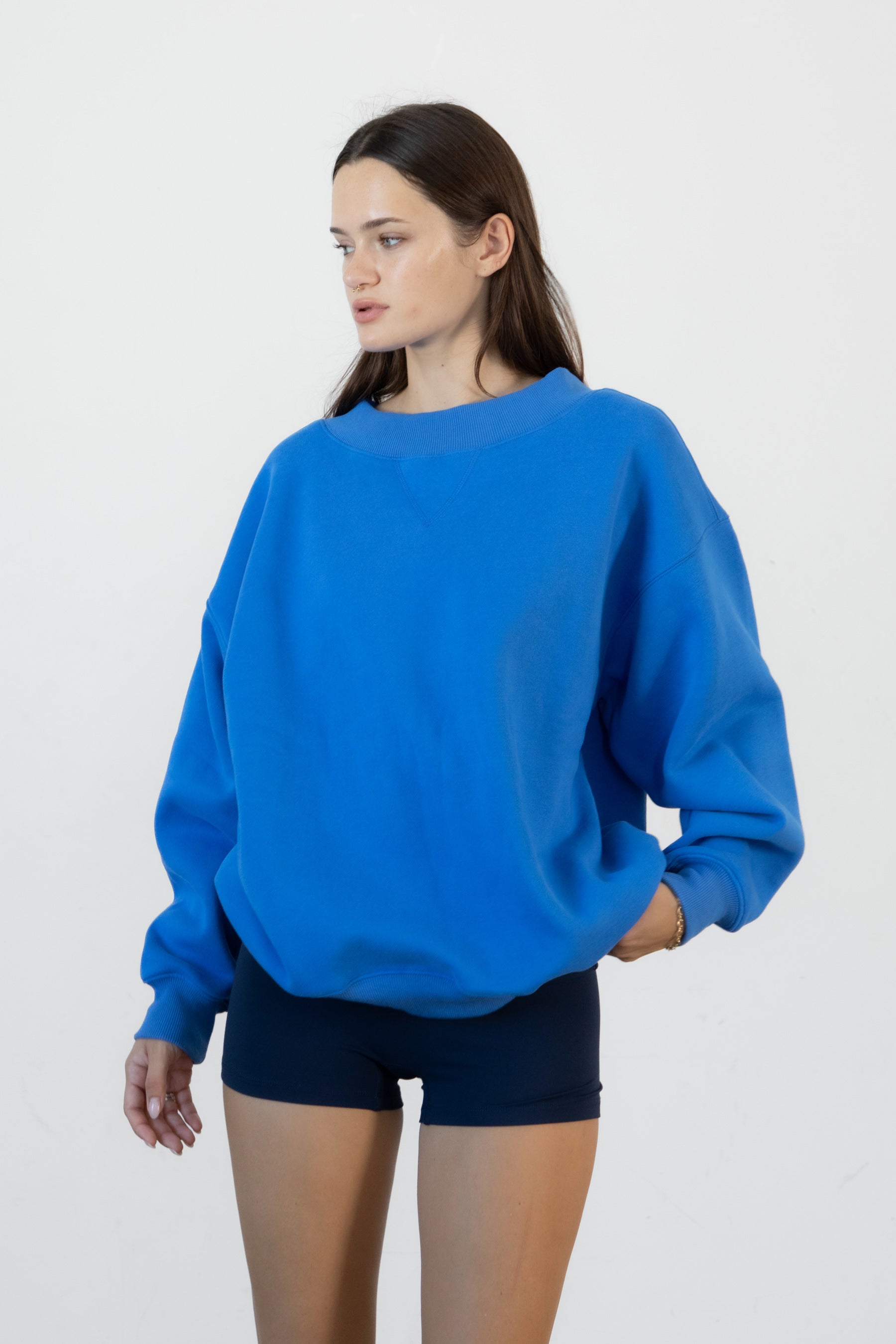 Woman wearing LANI mock neck cloud fleece sweatshirt featuring soft cotton blend cloud fleece fabric, ribbed mock neckline, relaxed oversized fit, dropped shoulder design, long sleeves with ribbed cuffs, triangle stitch detail at center front, and ribbed hem for a cozy comfortable finish.