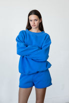 Woman wearing LANI mock neck cloud fleece sweatshirt featuring soft cotton blend cloud fleece fabric, ribbed mock neckline, relaxed oversized fit, dropped shoulder design, long sleeves with ribbed cuffs, triangle stitch detail at center front, and ribbed hem for a cozy comfortable finish.