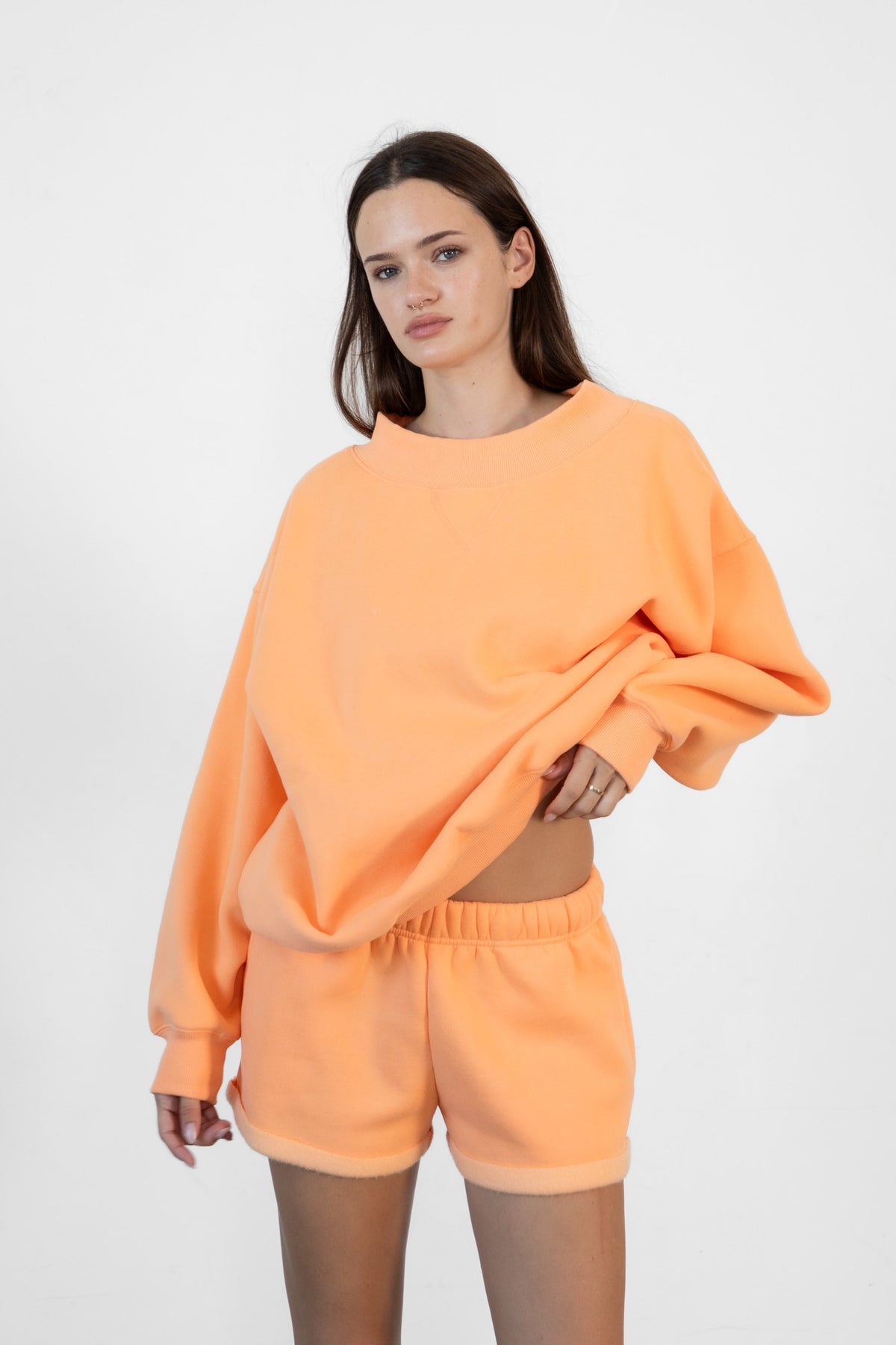 Woman wearing LANI mock neck cloud fleece sweatshirt featuring soft cotton blend cloud fleece fabric, ribbed mock neckline, relaxed oversized fit, dropped shoulder design, long sleeves with ribbed cuffs, triangle stitch detail at center front, and ribbed hem for a cozy comfortable finish.