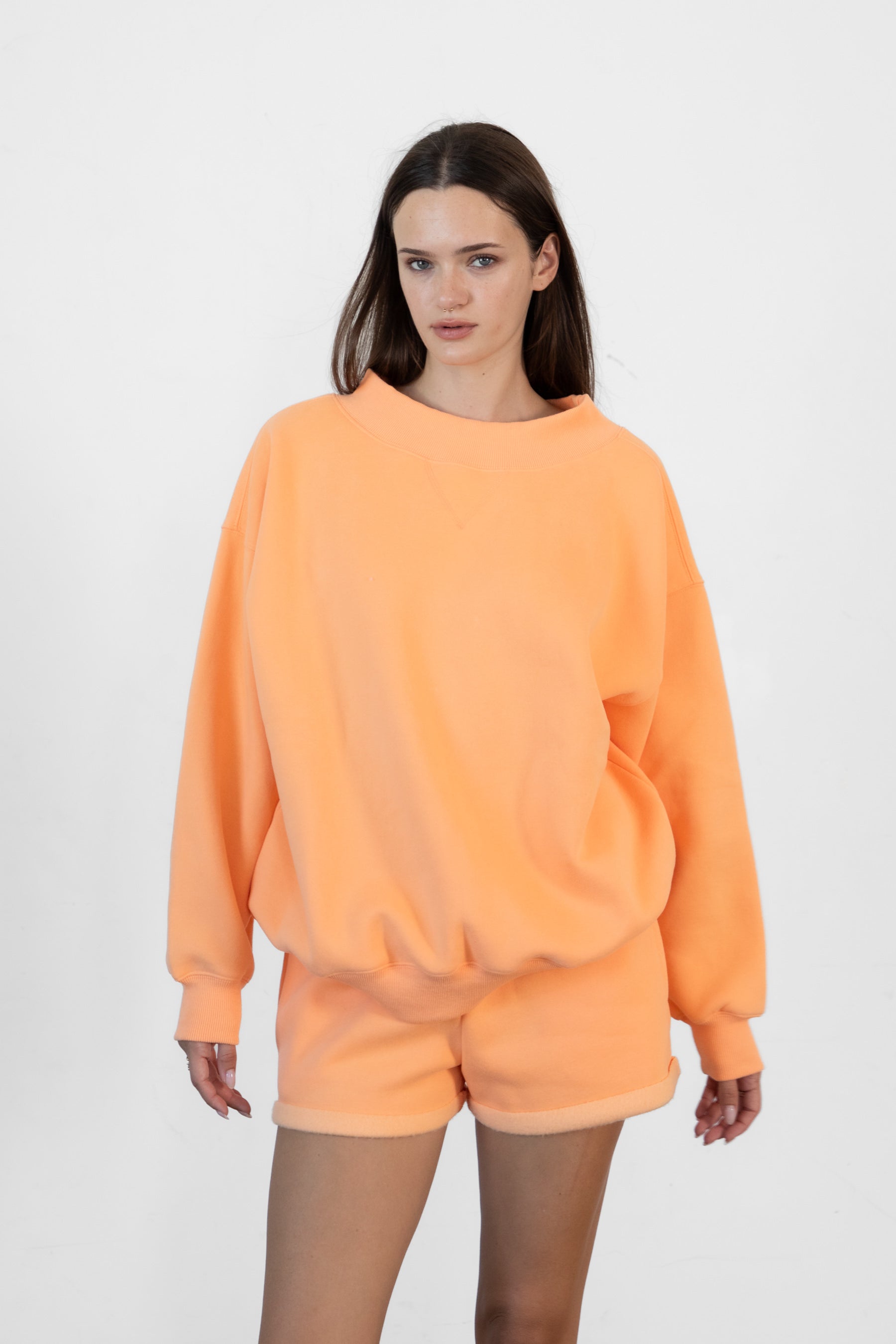 Woman wearing LANI mock neck cloud fleece sweatshirt featuring soft cotton blend cloud fleece fabric, ribbed mock neckline, relaxed oversized fit, dropped shoulder design, long sleeves with ribbed cuffs, triangle stitch detail at center front, and ribbed hem for a cozy comfortable finish.