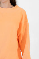 Woman wearing LANI mock neck cloud fleece sweatshirt featuring soft cotton blend cloud fleece fabric, ribbed mock neckline, relaxed oversized fit, dropped shoulder design, long sleeves with ribbed cuffs, triangle stitch detail at center front, and ribbed hem for a cozy comfortable finish.