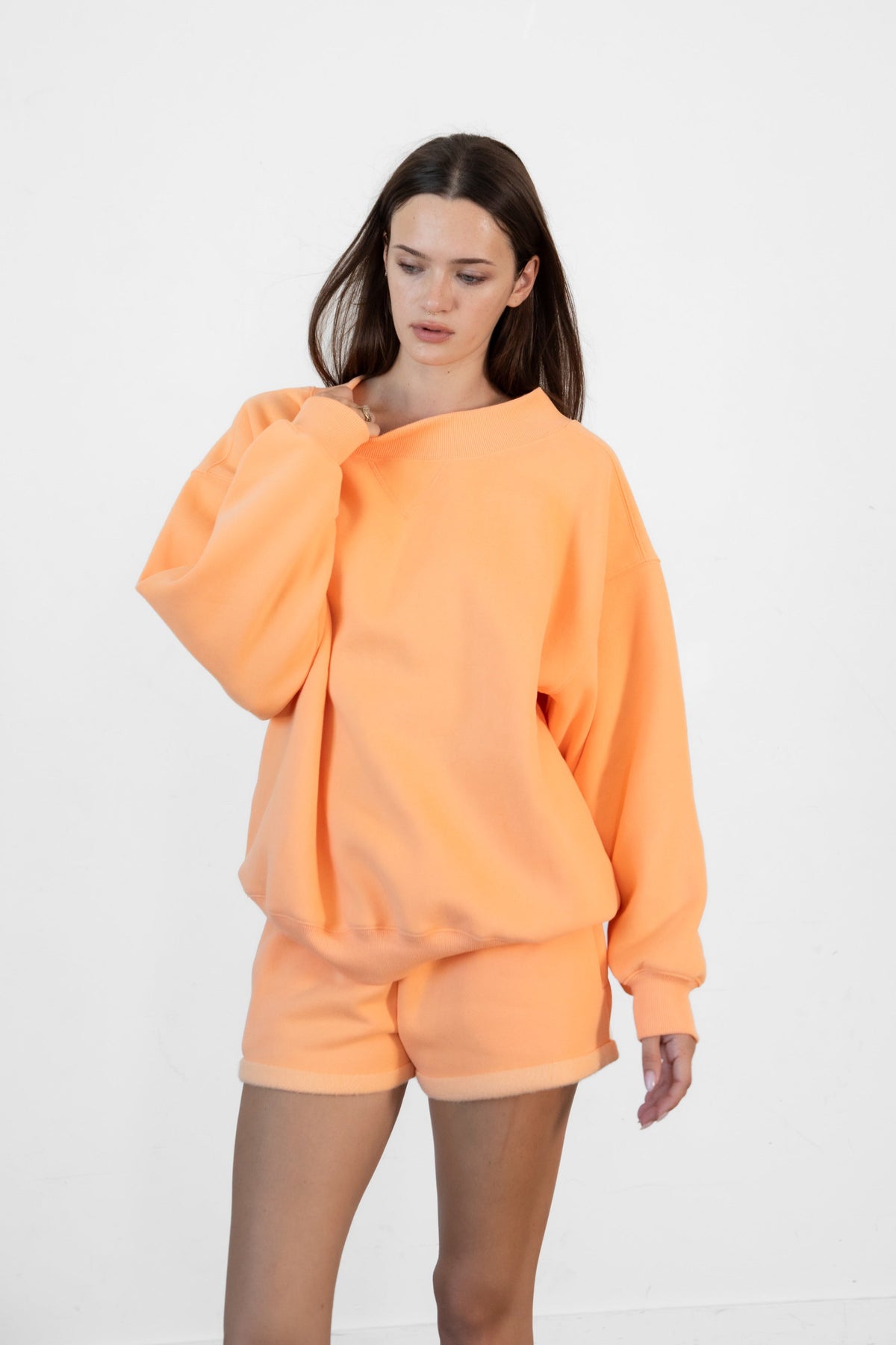 Woman wearing LANI mock neck cloud fleece sweatshirt featuring soft cotton blend cloud fleece fabric, ribbed mock neckline, relaxed oversized fit, dropped shoulder design, long sleeves with ribbed cuffs, triangle stitch detail at center front, and ribbed hem for a cozy comfortable finish.