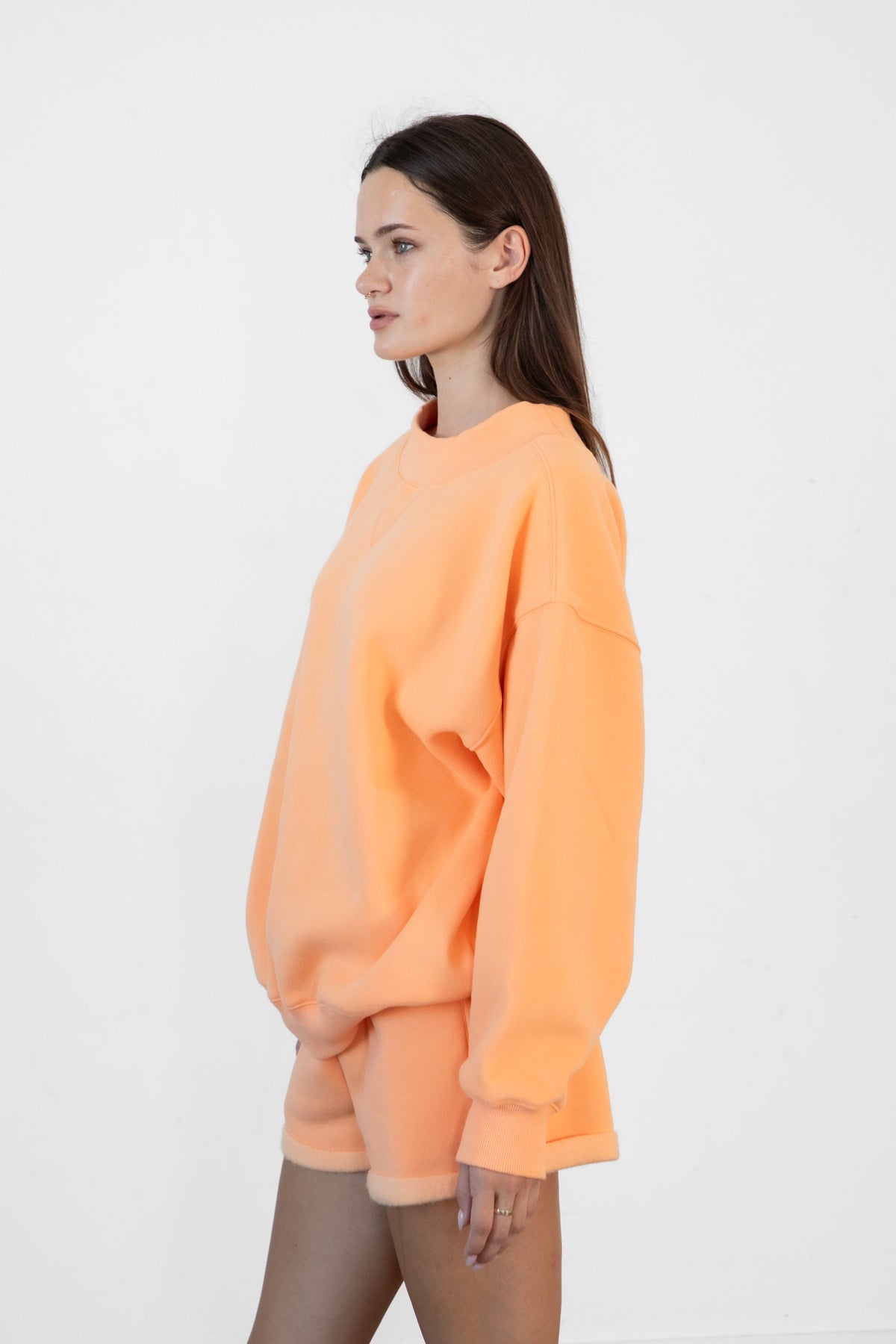 Woman wearing LANI mock neck cloud fleece sweatshirt featuring soft cotton blend cloud fleece fabric, ribbed mock neckline, relaxed oversized fit, dropped shoulder design, long sleeves with ribbed cuffs, triangle stitch detail at center front, and ribbed hem for a cozy comfortable finish.