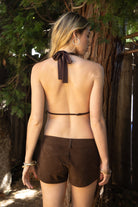 Woman wearing VEDA beaded embroidered cowl halter top featuring a deep draped cowl neckline, halter neck with self tie closure, floral beaded and sequin embroidery at the front, front bust strap detail, open back with adjustable strap, and lightweight sheer chiffon fabric.