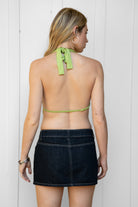 Woman wearing VEDA beaded embroidered cowl halter top featuring a deep draped cowl neckline, halter neck with self tie closure, floral beaded and sequin embroidery at the front, front bust strap detail, open back with adjustable strap, and lightweight sheer chiffon fabric.