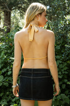 Woman wearing VEDA beaded embroidered cowl halter top featuring a deep draped cowl neckline, halter neck with self tie closure, floral beaded and sequin embroidery at the front, front bust strap detail, open back with adjustable strap, and lightweight sheer chiffon fabric.