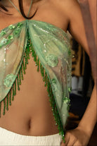Woman wearing TIC TOC TL31629-SERAYA SERAYA beaded tassel embellished mesh halter scarf top featuring sheer embroidered mesh fabric with floral appliqué and sequin accents, beaded tassel fringe along the hem, halter neck tie closure, and an open back with adjustable tie, styled over a simple bralette and low-rise bottoms for a bold festival and resort-ready statement look.