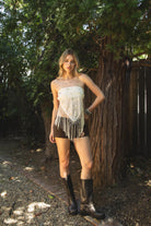 Woman wearing VEYONA beaded sequin tassel scarf top featuring a strapless pointed scarf silhouette, allover sequin and bead embroidery, knotted tassel fringe hem, double strap self tie back design, and lightweight chiffon fabric with bust lining and a draped front shape.