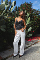 Woman wearing TIC TOC TL31684 AURYA chiffon sequin beaded cowl neck top featuring a draped cowl neckline, floral sequin and beaded embroidery, thin adjustable straps with cross back detail, fitted cropped silhouette, and asymmetrical hemline for a feminine festival and night-out look.